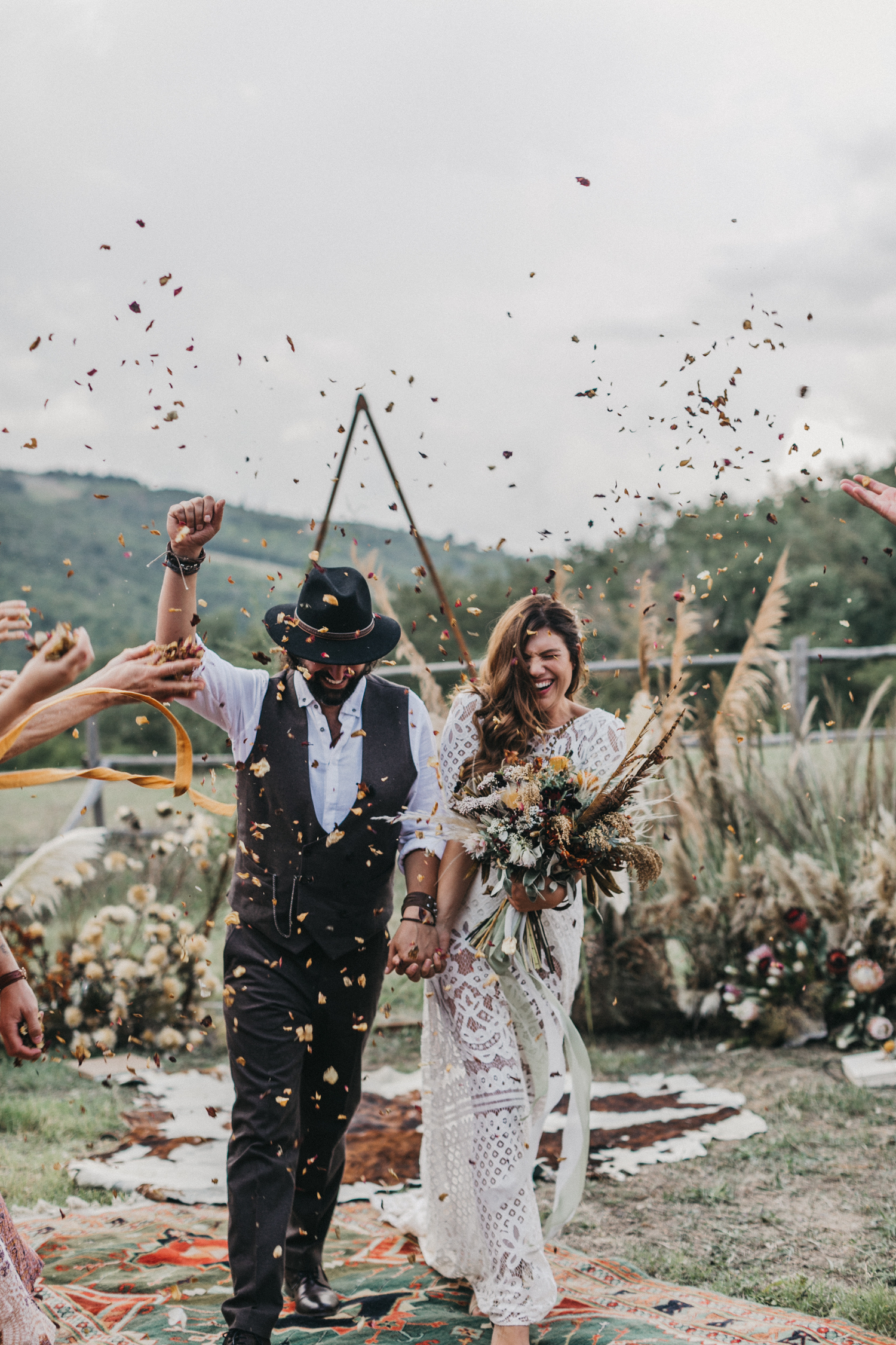 Auf einer Toskana Hochzeit wird das Hochzeitspaar in einem Blumenregen gefeiert.