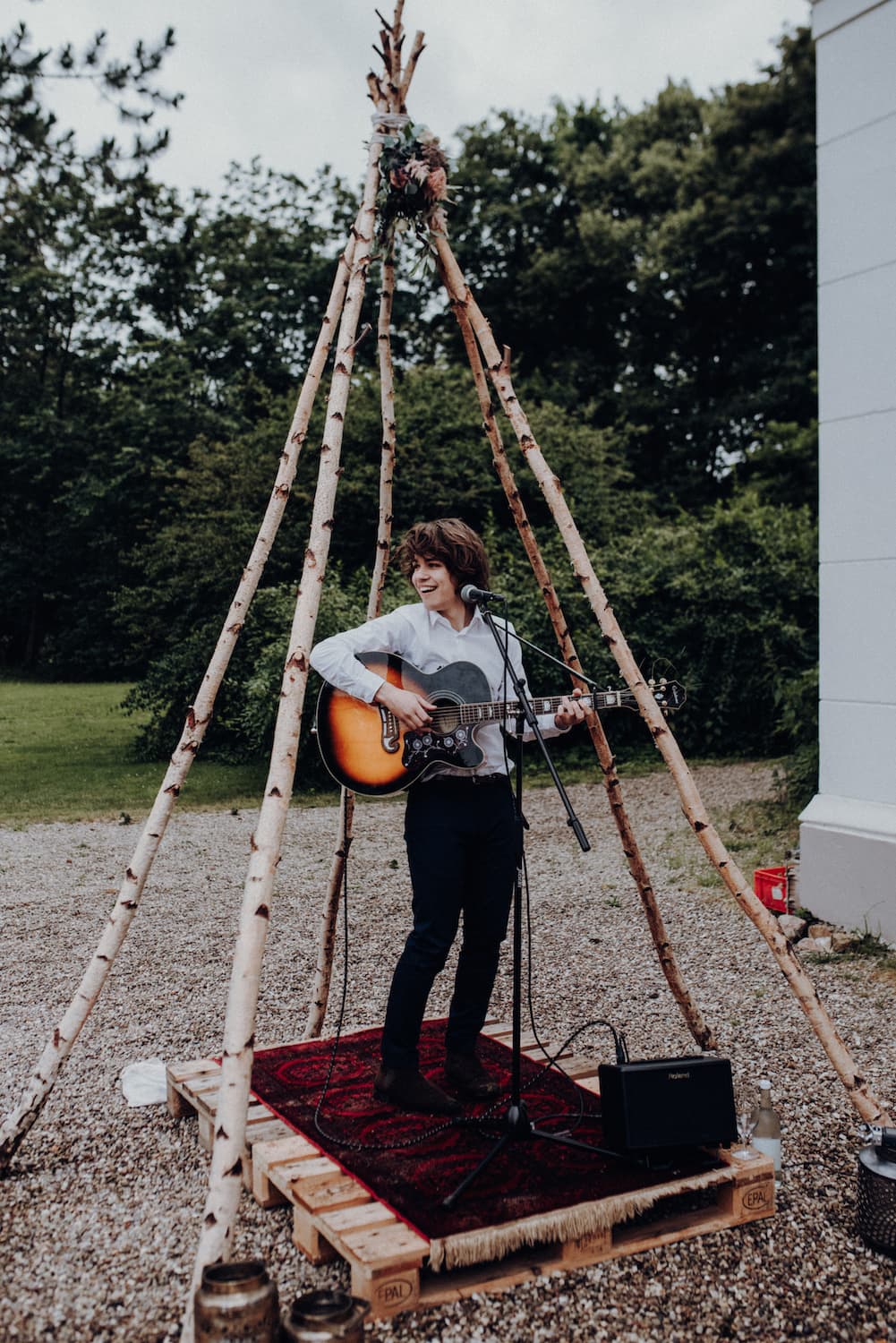 Hochzeitssänger Julian LeBen musiziert vor dem Herrenhaus Gut Bliestorf auf einer Hochzeit im Boho-Stil.