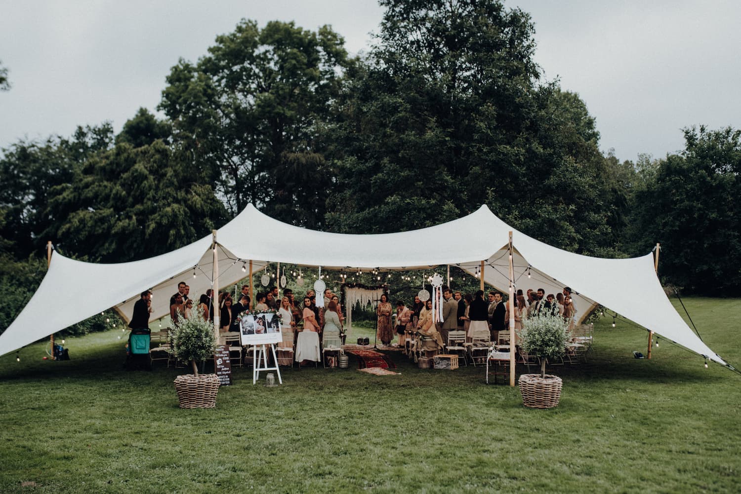 Festzelt mit Gästen auf einer Boho-Hochzeit im Herrnhaus Gut Bliestorf.