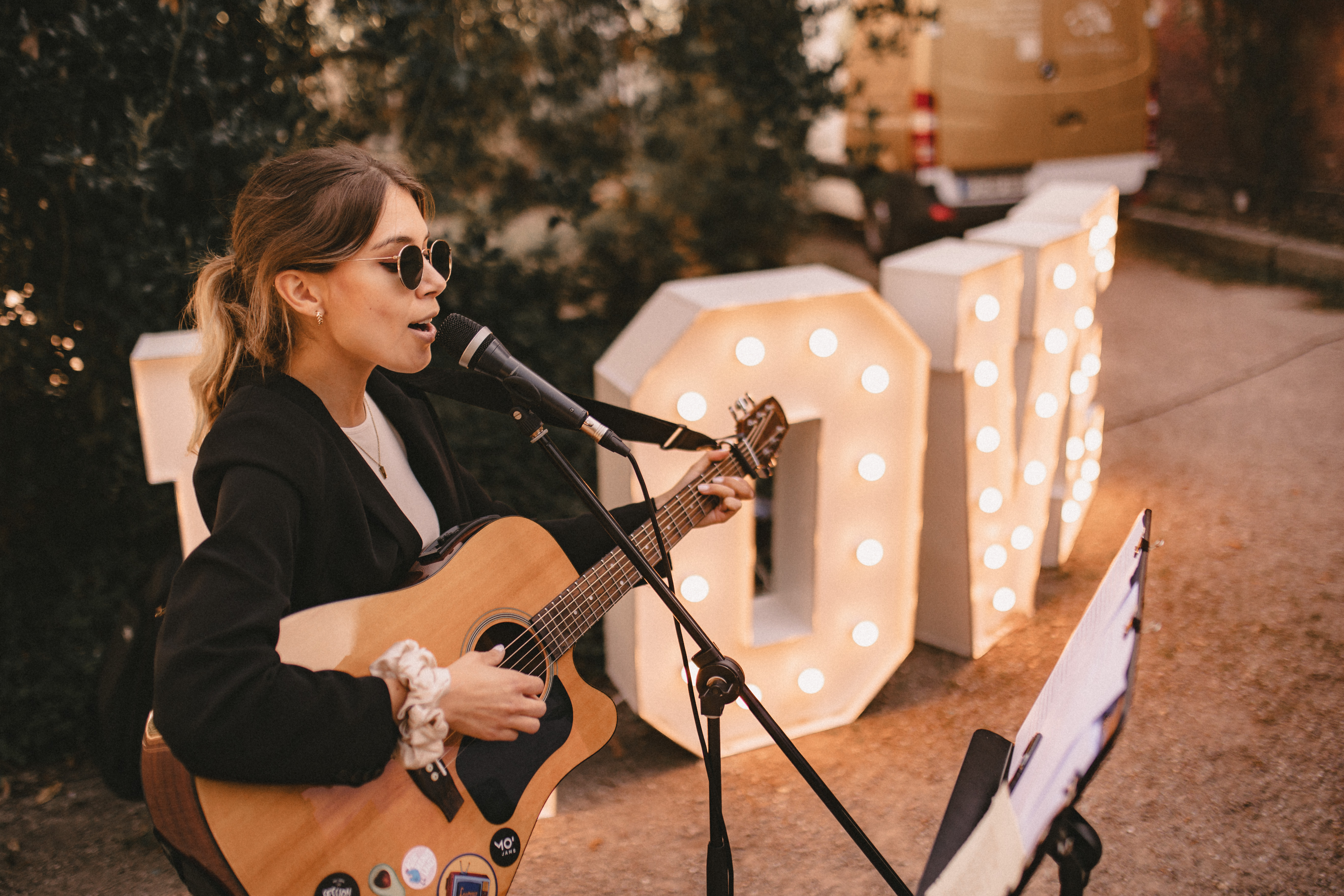 Sängerin mit Gitarre spielt erfolgreich auf einem Event, für das sie über Herzwispern gebucht wurde.
