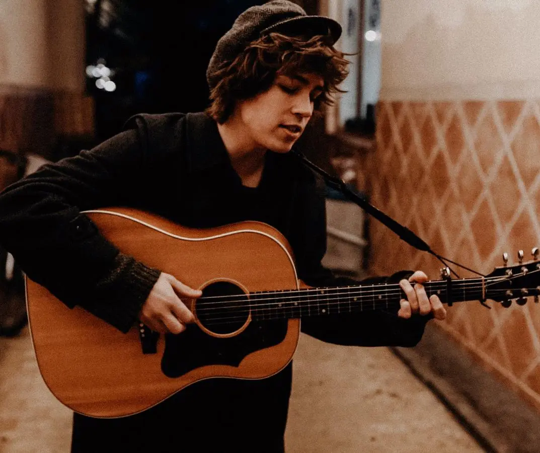 Sänger Julian LeBen singt und spielt Gitarre auf der Straße.