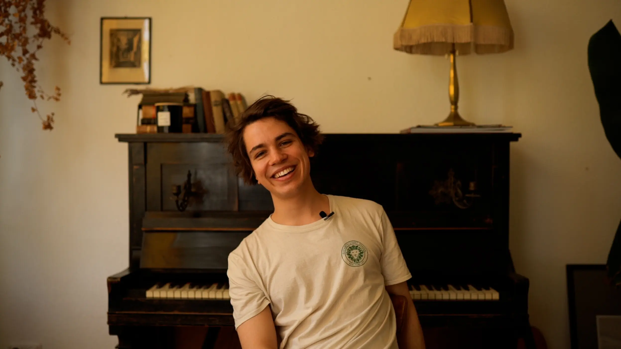 Sänger Julian LeBen sitzt vor einem Klavier und wird fotografiert, dies ist Teil der Herzwispern Videodrehs.