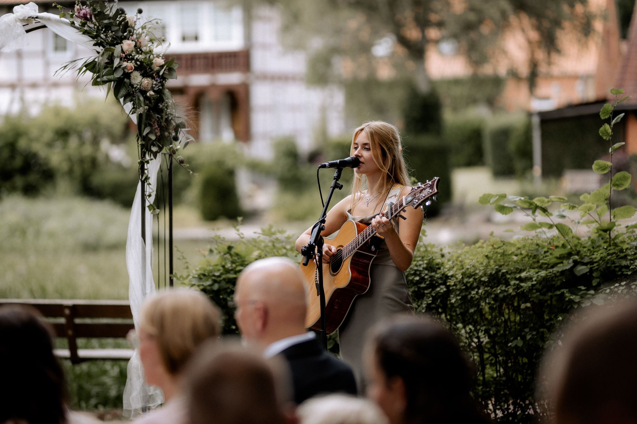 Sängerin mit Gitarre begleitet eine freie Trauung mit Live-Musik.