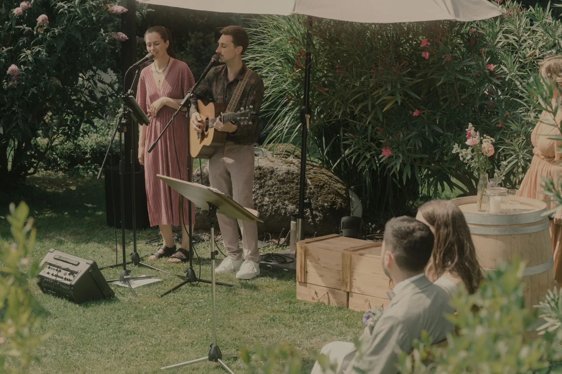 Sängerin und Sänger mit Gitarre singen für das Hochzeitspaar bei einer freien Trauung.