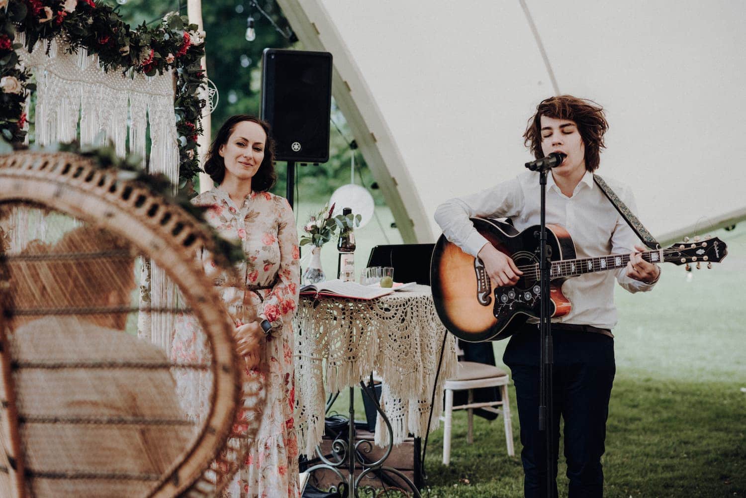 Hochzeitssänger Julian LeBen singt auf der Trauung einer Boho-Hochzeit, neben ihm steht die Hochzeitsrednerin.