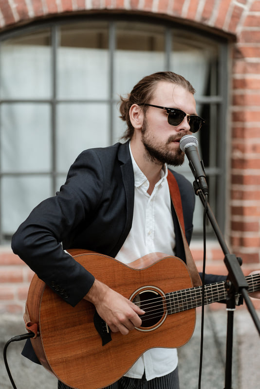 Sänger Will Church singt und spielt Gitarre auf Hochzeit in Schloss Gamehl.