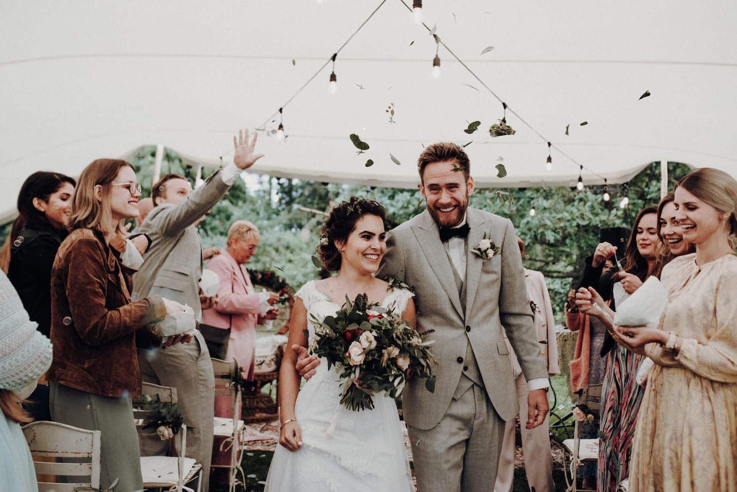 Hochzeitspaar wird gefeiert im Spalier auf Boho-Hochzeit.